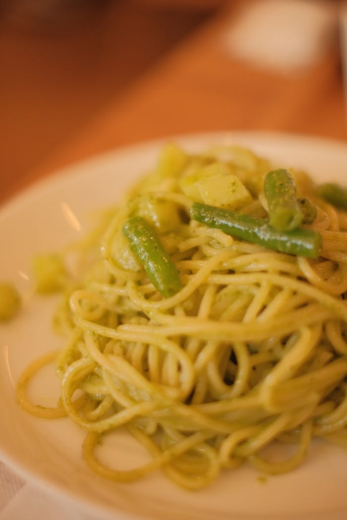 services-04 Appetizing Italian pasta with green beans and pesto sauce, perfect for food enthusiasts.